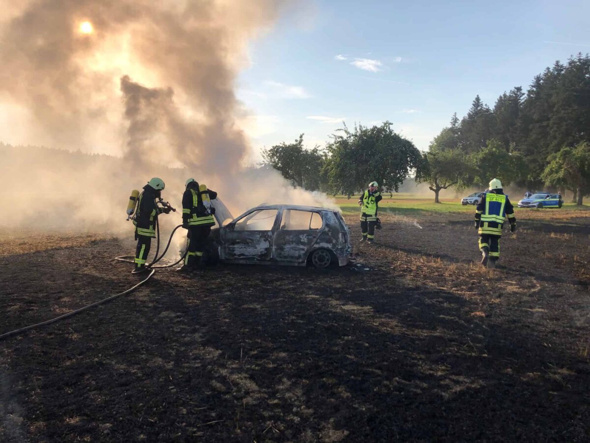 Feuerwehrleute löschen das brennende Auto bei Winzeln. Fotos: Emil Moosmann