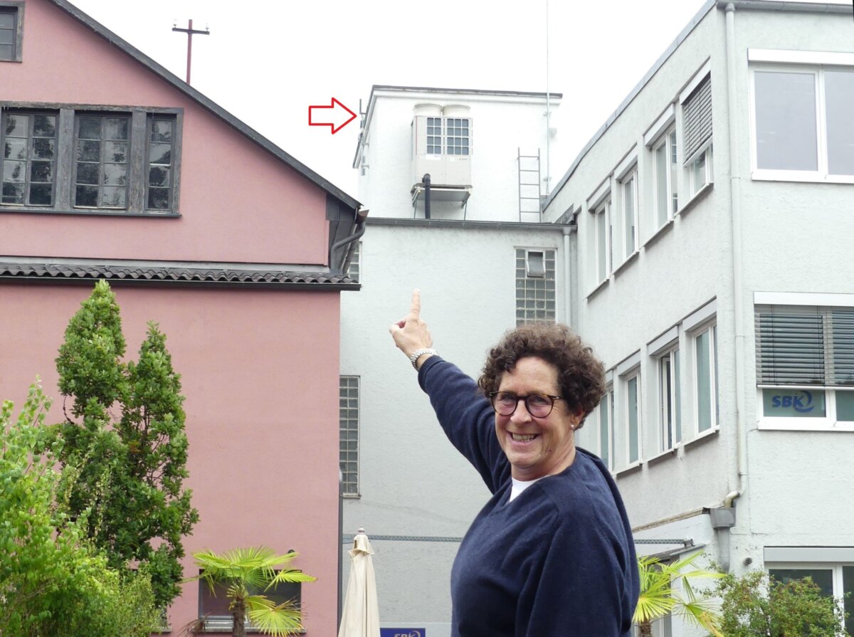Hoch droben: Annette Melvin zeigt auf die neue Wetterstation am Majolika-Gebäude. Foto: him