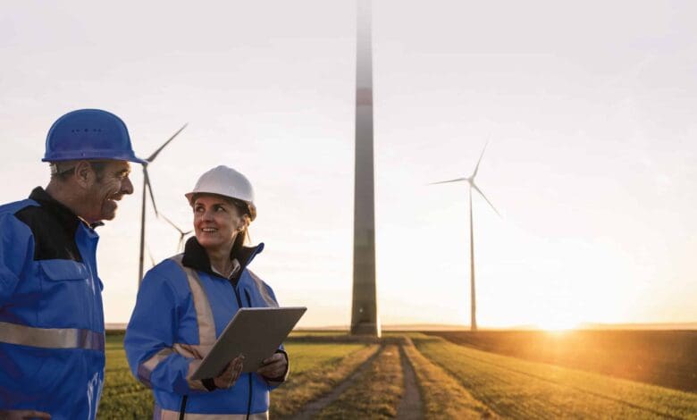engineers wearing hardhats discussing at sunset