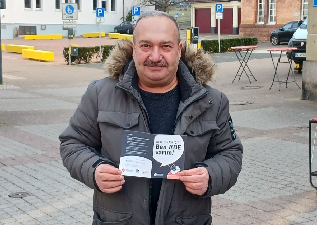 Ibrahim Er wirbt mit zweisprachigem Flyer fürs Wählen. Foto: him