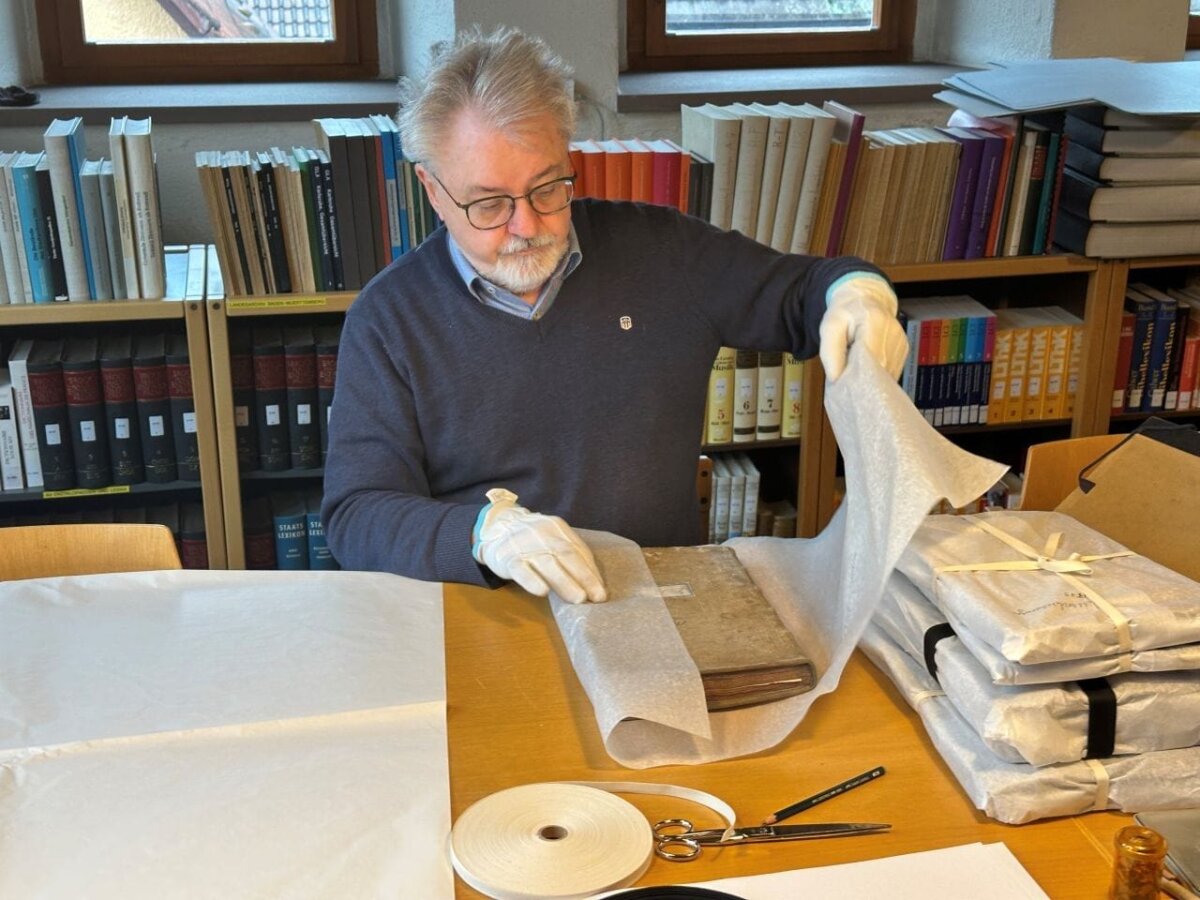 Arved Sassnick beim Verpacken eines historischen Buchs im Stadtarchiv (Foto: Stadt Rottweil / Florian Schick).