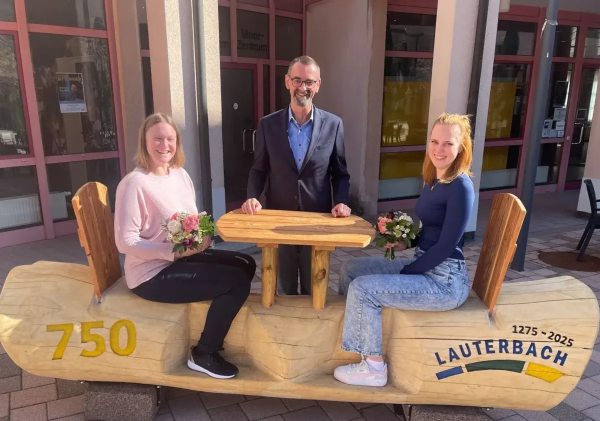 Sandra Bartels, Bürgermeister Jürgen Leichtle und Maike Fehrenbacher auf dem neuen Jubiläums-Holzsofa anlässlich „750 Jahre Lauterbach" (von links).  Foto: pm