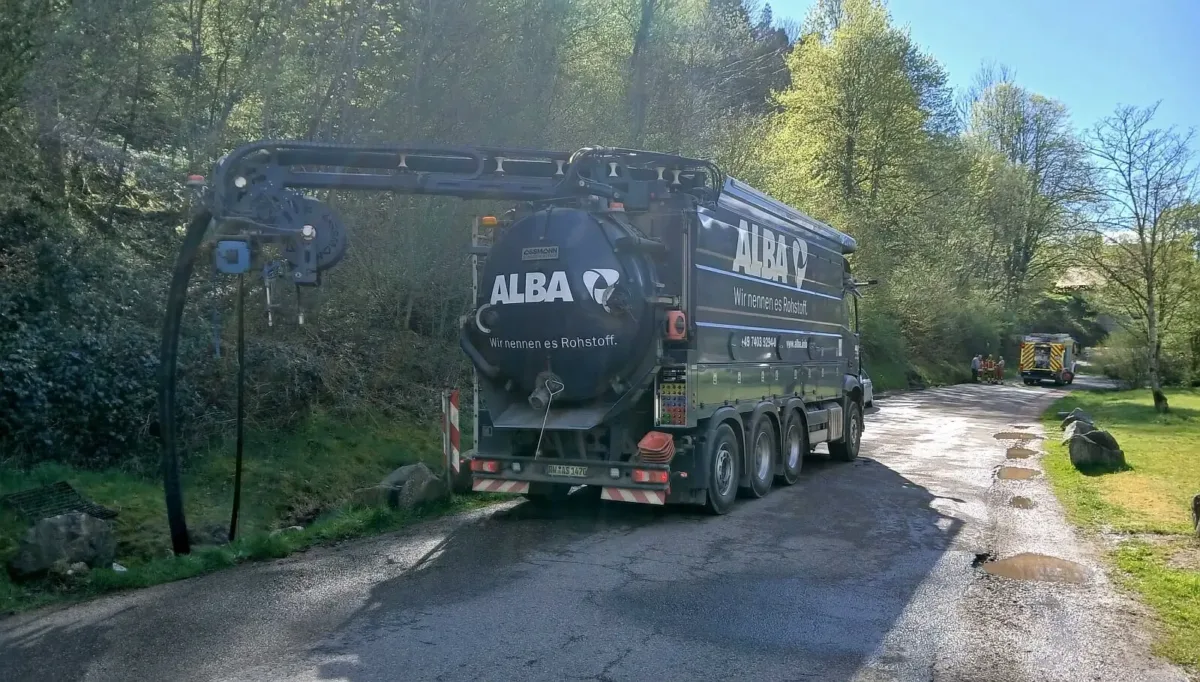 Mitarbeiter von Alba saugen das ölige Wasser am Parkplatz ab.  Foto: Umweltamt
