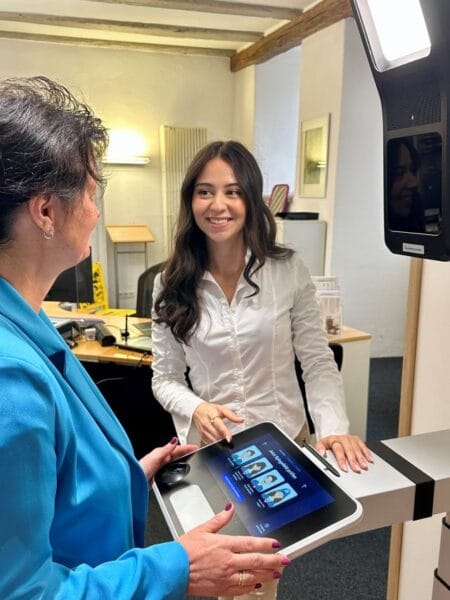 Im Bürgerbüro im Alten Rathaus können Passbilder mithilfe einer digitalen Technik selbst aufgenommen werden. Mitarbeiterinnen des Bürgerbüros sind bei der Bedienung des Geräts „PointID“ der Bundesdruckerei behilflich. Auch bei zertifizierten Fotografen ist das digitale Passbild erhältlich. Foto: Stadt Rottweil/Hermann