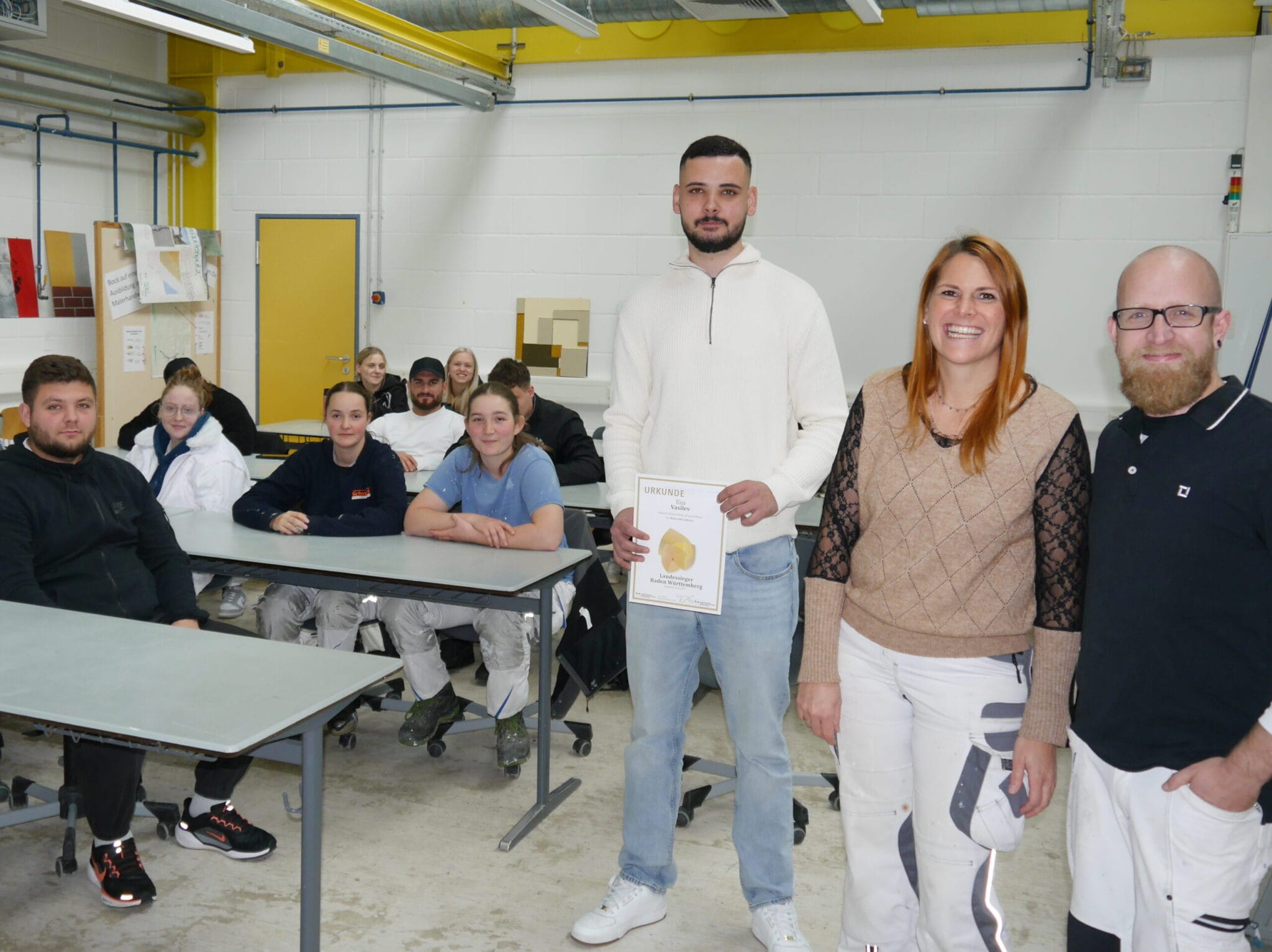 Der Landessieger der Maler und Lackierer Ilija Vasilev (stehende links) hat seine ehemalige Schule besucht und den Auszubildenden von seinem Werdegang und dem Wettkampf berichtet. Stolz auf dieses Ergebnis sind auch seine ehemaligen Lehrkräfte Matthias Sieber (rechts) und Madeleine Fuentes (2. von rechts). Foto: pm