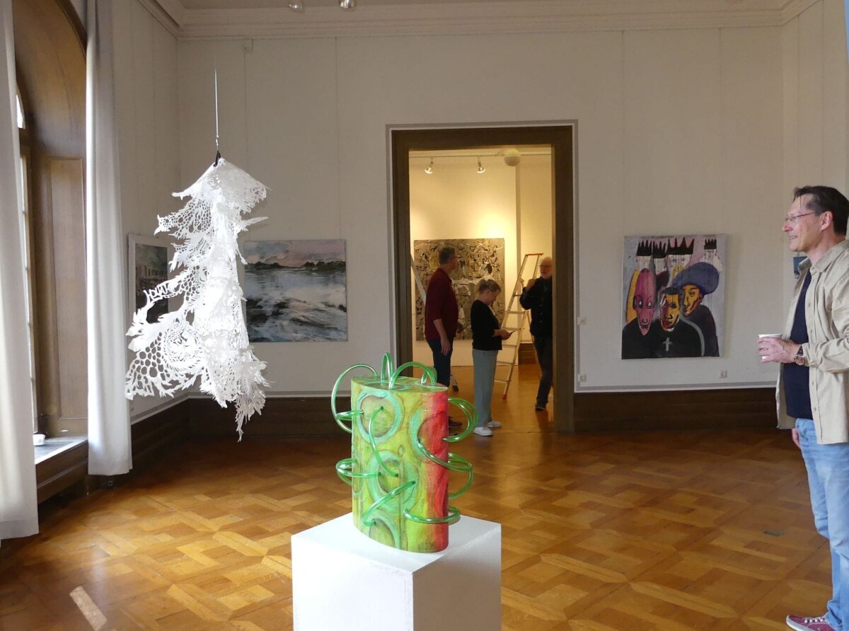 Blick in die Mitgliederausstellung: Im Vordergrund eine Plastik von Ingrid Wild, dahinter ein Scherenschnitt von Miriam Huschenbeth. Foto: him