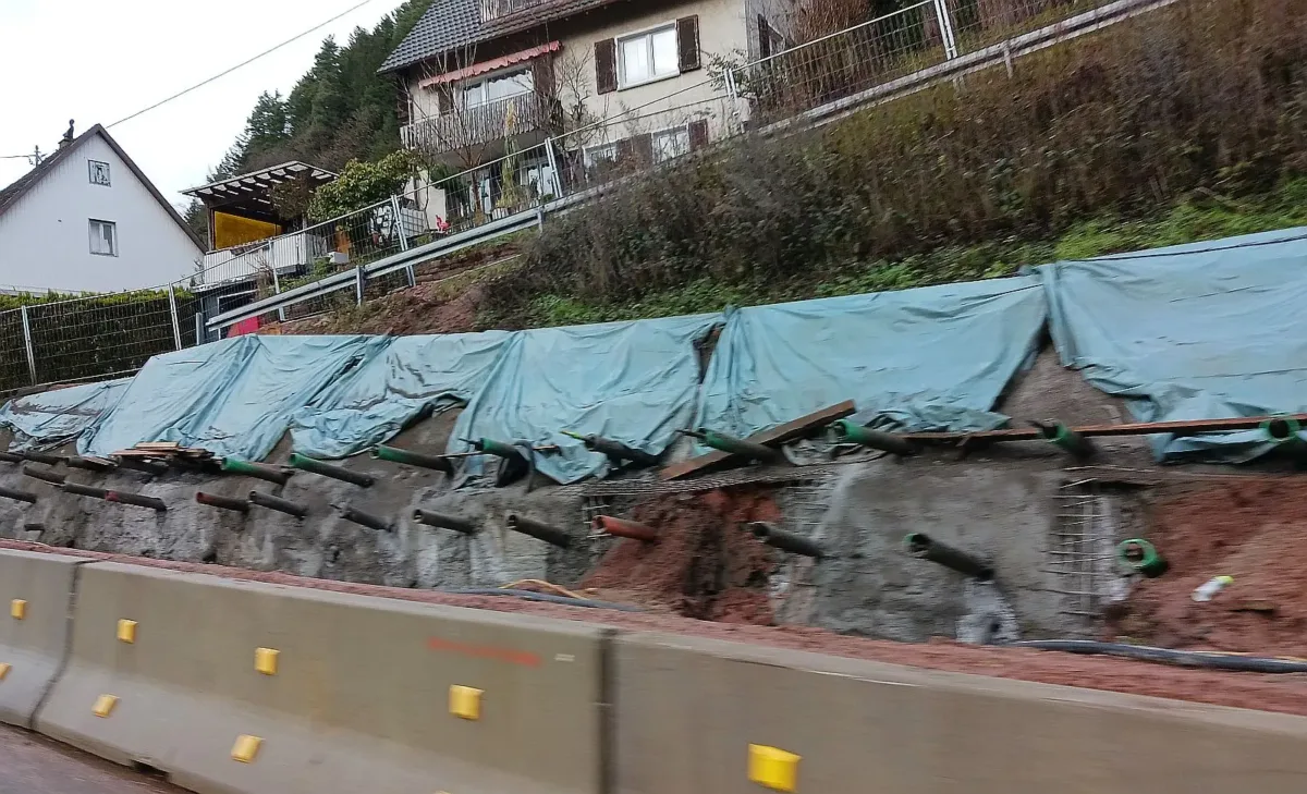 Die Bauarbeiten am oberen Teil der Stützmauer laufen. Zu erkennen: die Mikropfähle, an denen die neue Stützmauer verankert wird. Foto: him
