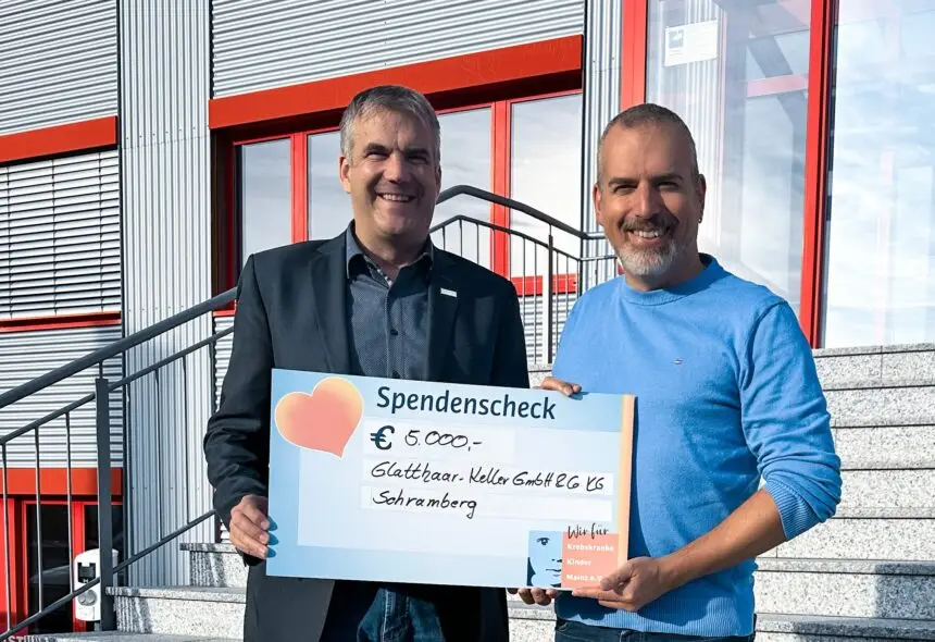 Geschäftsführer Michael Gruben (links) überreicht Vorstand Kai Leimig einen Scheck über 5.000 Euro für die Arbeit des Vereins „Krebskranke Kinder Mainz e.V.“ Foto: Glatthaar Keller / Melanie Mähringer-Kunz