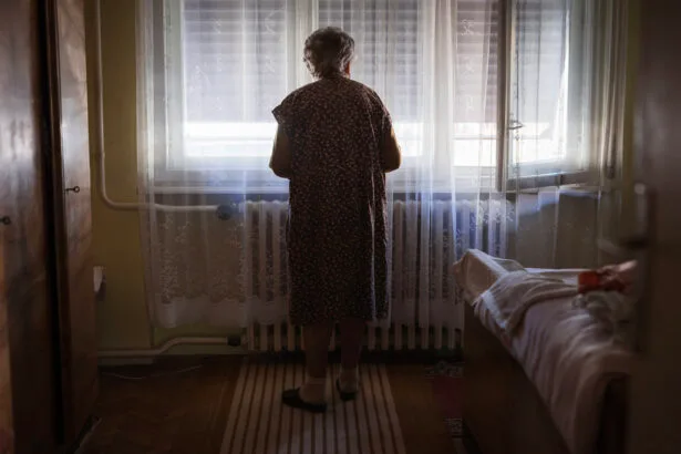 senior woman looking through window curtain
