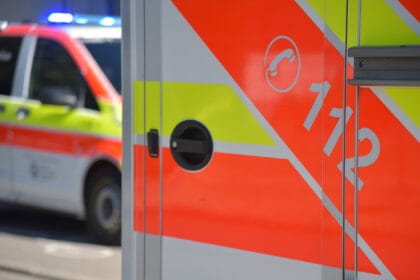 Rettungswagen in Deutschland mit Notrufnummer 112 auf rotem und gelbem Streifen für Notdienste.