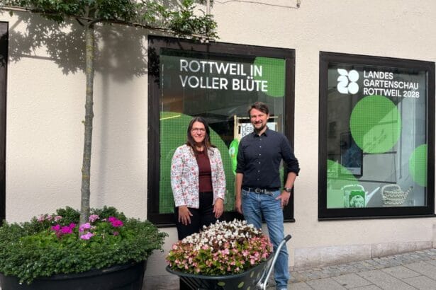 Personen bei Rottweil in voller Blüte vor Schaufenster der Landesgartenschau 2028. Pflanzkübel im Vordergrund.