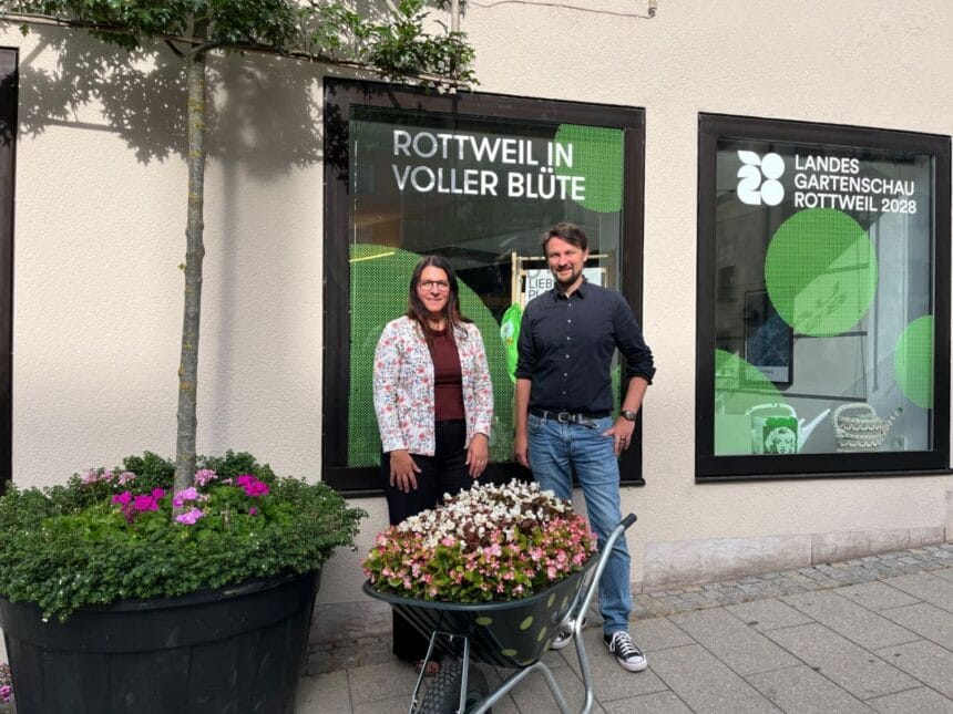 Personen bei Rottweil in voller Blüte vor Schaufenster der Landesgartenschau 2028. Pflanzkübel im Vordergrund.