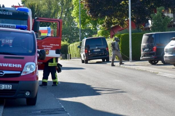 Feuerwehr und Polizei im Einsatz auf einer Straße in der Stadt, Löschfahrzeug und Polizei-Van vor Ort.