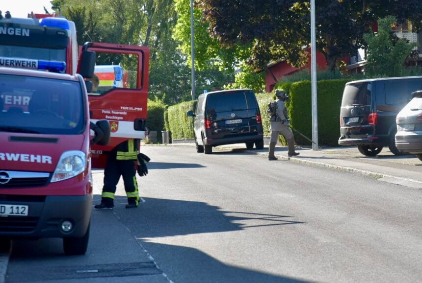 Feuerwehr und Polizei im Einsatz auf einer Straße in der Stadt, Löschfahrzeug und Polizei-Van vor Ort.