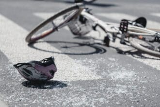 closeup of kid's helmet and bike on a pedestrian lines after danger incident with a car