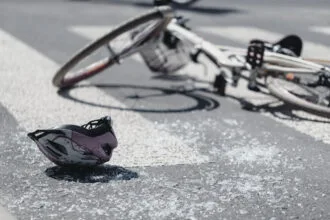 closeup of kid's helmet and bike on a pedestrian lines after danger incident with a car