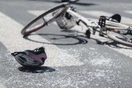 closeup of kid's helmet and bike on a pedestrian lines after danger incident with a car
