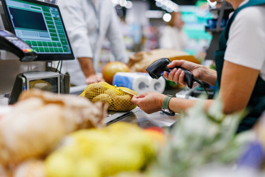 cashier scanning groceries at checkout in supermarket