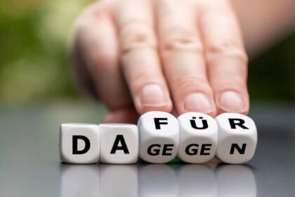 hand turns dice and changes the german word "against" (cons) to "dafuer" (pros)