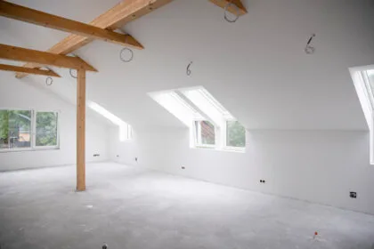 attic construction site freshly painted, the floor is still screed, walls are white