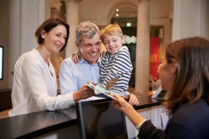 family buying entry tickets to museum from reception