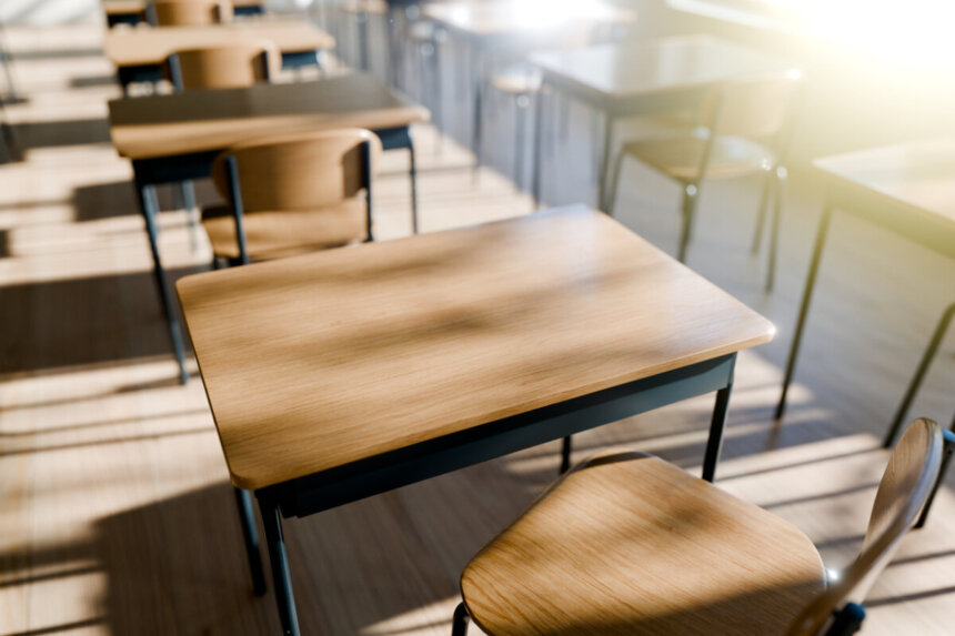 minimalist classroom setting with wooden desks emphasizing a peaceful learning environment filled with natural light. 3d render.