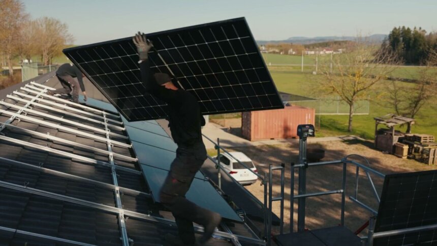 Montage der Photovoltaikanlage auf dem Vereinsheim, im Hintergrund der Ballpark der Cavemen