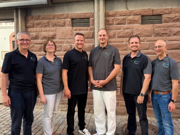 Das Team der Praxis Schwarzwaldzentrum, sechs Personen in einheitlicher Kleidung vor einer Backsteinwand.